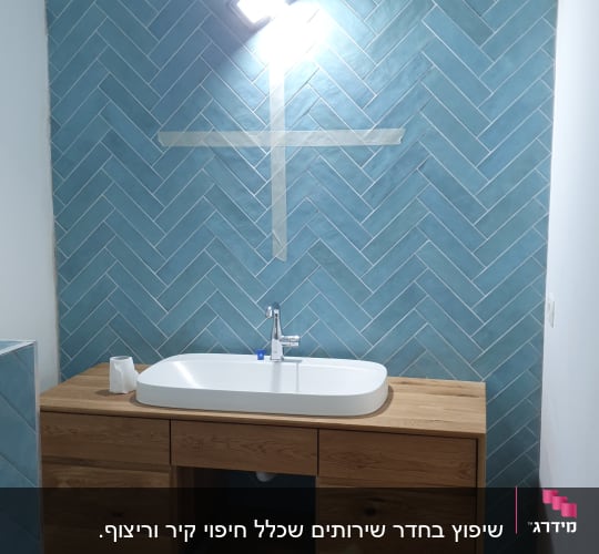 כיור מותקן על ארון עץ, קיר אריחים כחולים